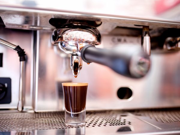 coffee dripping from a portafilter into an espresso cup