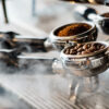 coffee grounds and beans inside two barista machine baskets