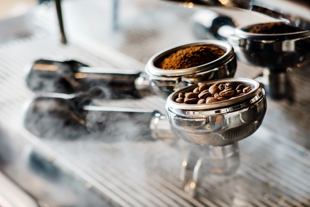 coffee grounds and beans inside two barista machine baskets