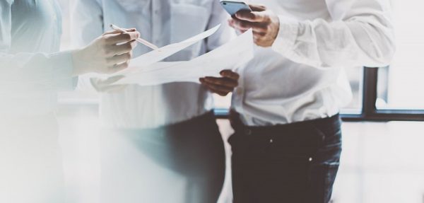 three men looking at worksheets