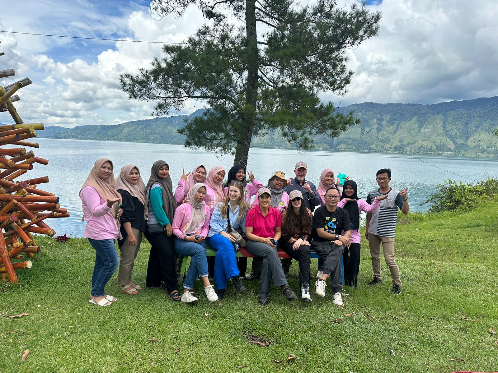 Group of people standing and sitting in front of a lake