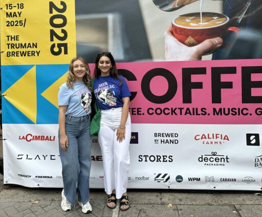 Laura McKitterick and Anushka Bedi standing in front of the London Coffee Festival 2025 sign